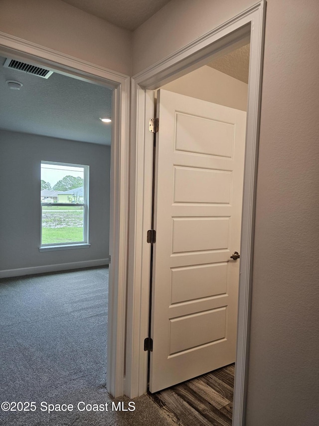 713 Degroodt Rd SW, Palm Bay, FL 32908 - hallway featuring dark carpet and baseboards