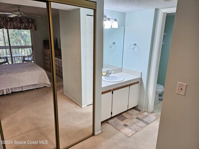 981 Sonesta Ave NE Unit 203, Palm Bay, FL 32905 - ensuite bathroom with ensuite bath, vanity, toilet, a textured ceiling, and a ceiling fan
