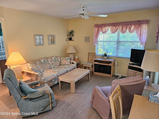 living room with hardwood / wood-style floors, a textured ceiling, and ceiling fan