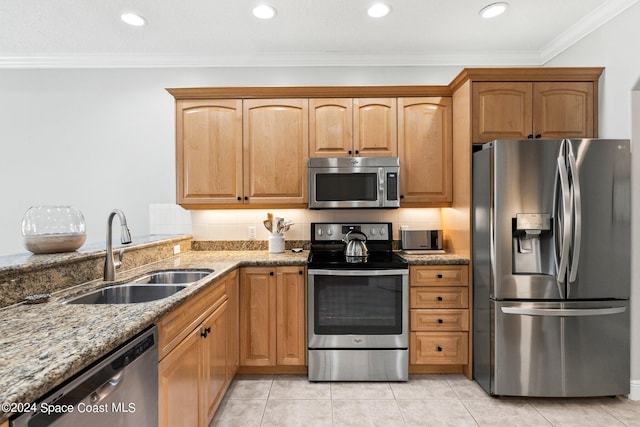 kitchen with appliances with stainless steel finishes, light tile patterned flooring, sink, light stone counters, and crown molding