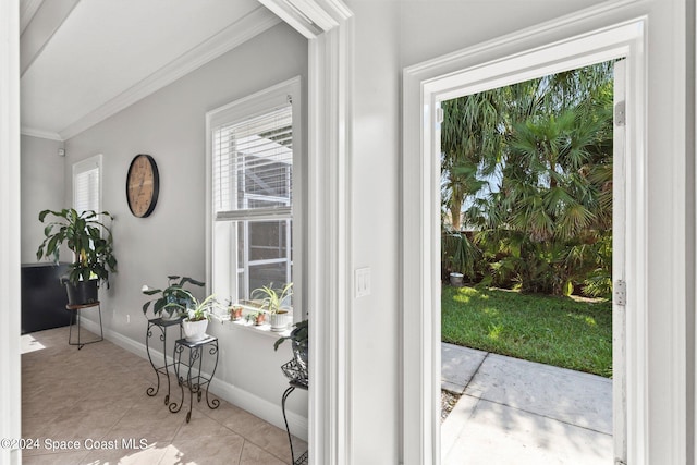 doorway with crown molding and light tile patterned floors