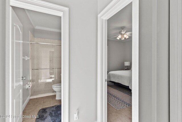 bathroom featuring ceiling fan, tile patterned flooring, toilet, and an enclosed shower