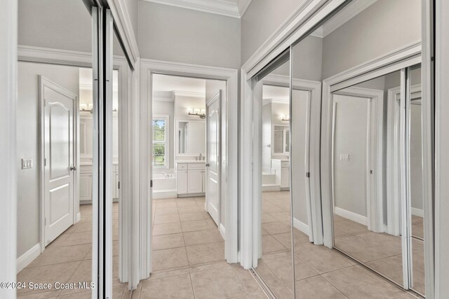 hall featuring crown molding and light tile patterned flooring