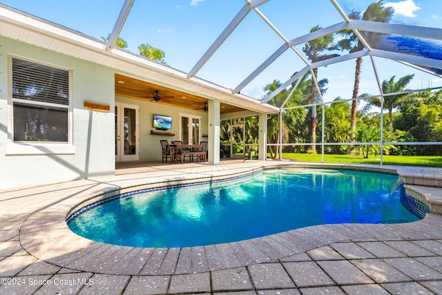 view of swimming pool featuring a patio, a lanai, and ceiling fan