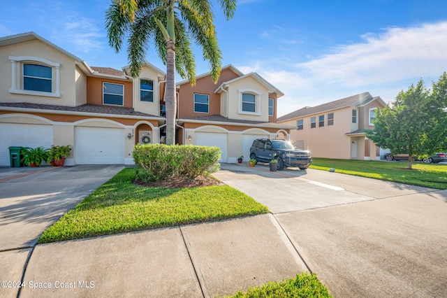 view of property featuring a front yard and a garage