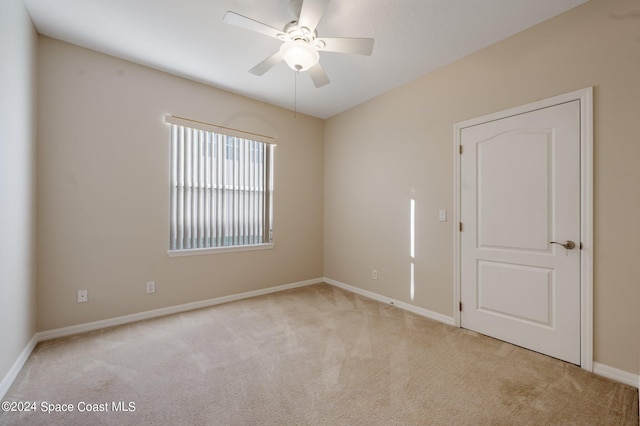 unfurnished room featuring light carpet and ceiling fan