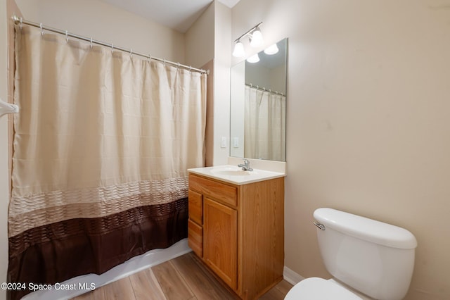 bathroom featuring vanity, hardwood / wood-style floors, curtained shower, and toilet