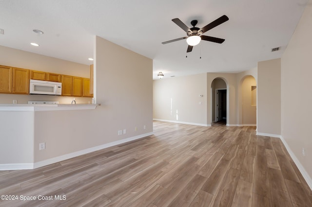 unfurnished living room featuring light wood-type flooring and ceiling fan