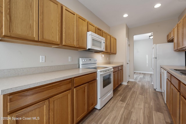 kitchen with light hardwood / wood-style floors and white appliances