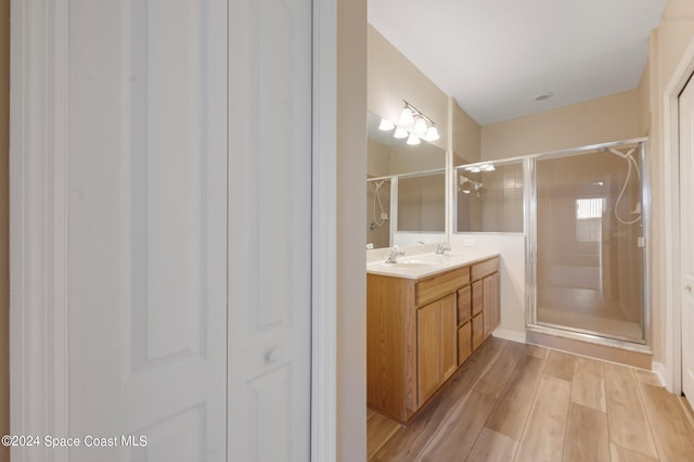 bathroom featuring vanity, hardwood / wood-style flooring, and a shower with shower door