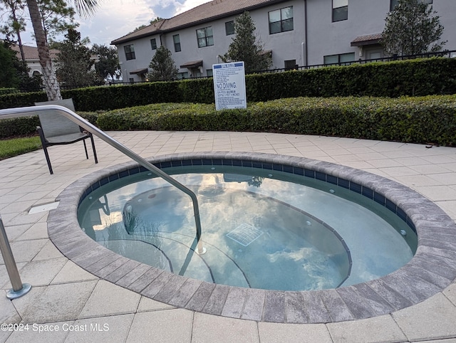 view of swimming pool with a hot tub