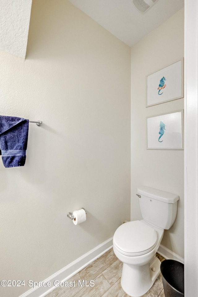 bathroom with hardwood / wood-style floors and toilet