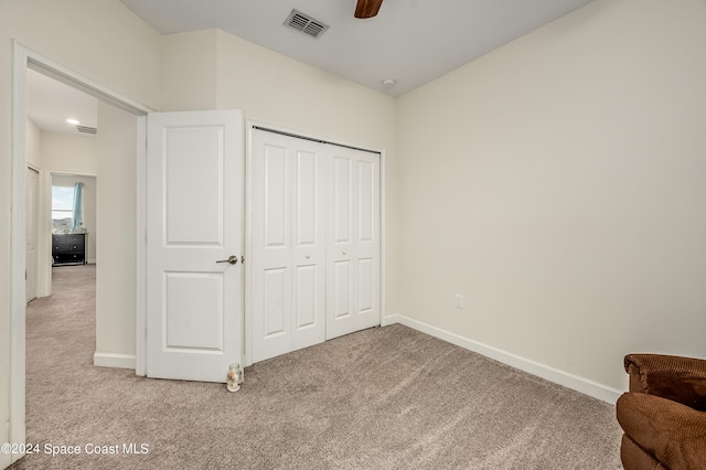 carpeted bedroom featuring ceiling fan and a closet