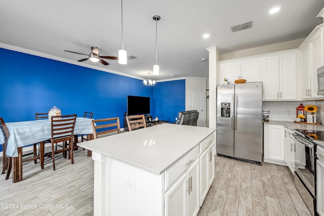 kitchen featuring light wood-type flooring, ceiling fan, a kitchen island, white cabinets, and appliances with stainless steel finishes