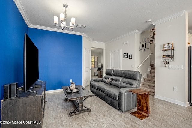 living room featuring light hardwood / wood-style floors, crown molding, and an inviting chandelier