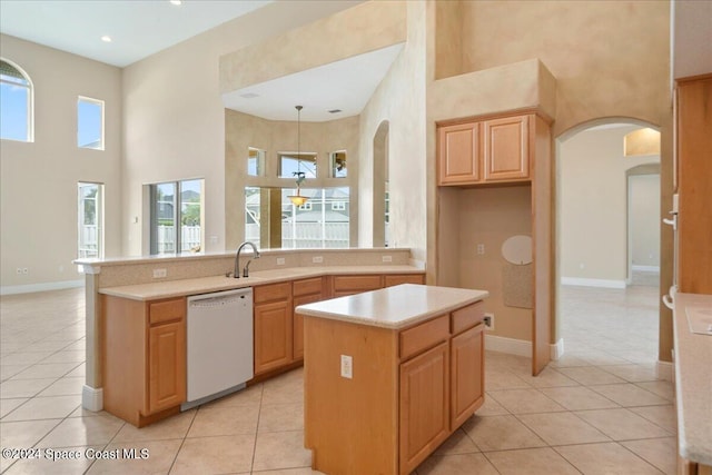 kitchen featuring a kitchen island, light brown cabinets, a high ceiling, light tile patterned floors, and dishwasher