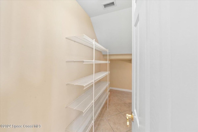 walk in closet with lofted ceiling and light tile patterned floors