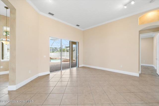 spare room featuring ornamental molding and light tile patterned floors