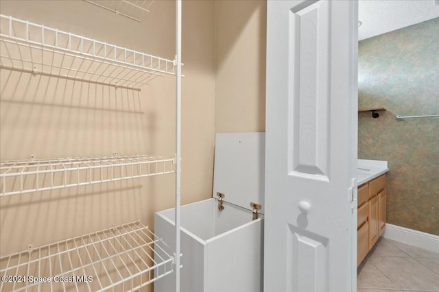 laundry area with light tile patterned floors