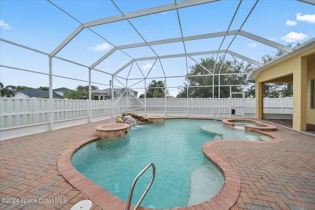 view of pool featuring an in ground hot tub, a patio, and a lanai