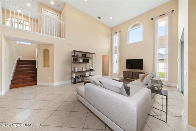 living room featuring a high ceiling, plenty of natural light, and light tile patterned flooring