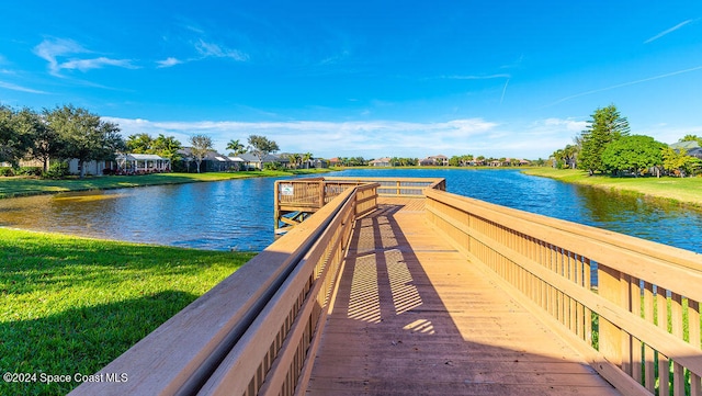 dock area with a lawn and a water view