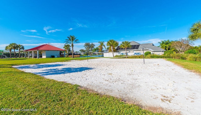 view of property's community featuring volleyball court and a lawn