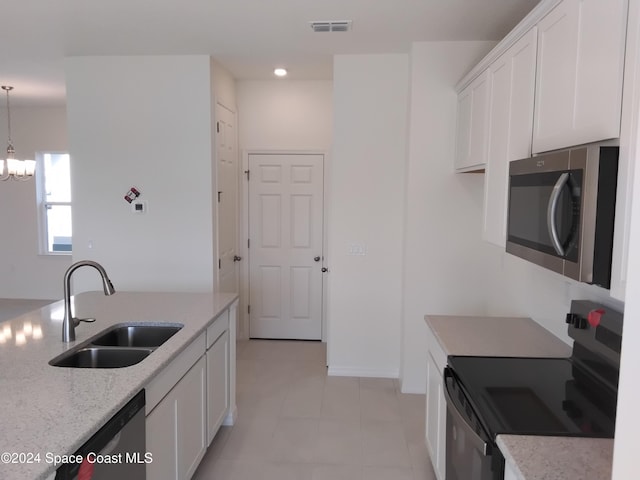 kitchen featuring sink, white cabinets, an inviting chandelier, and appliances with stainless steel finishes