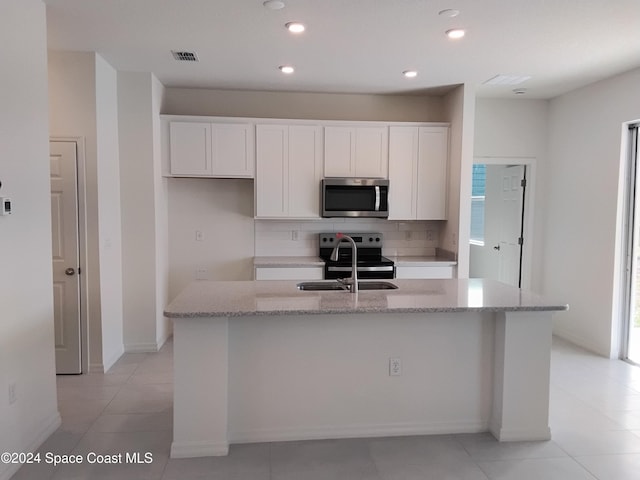 kitchen with stainless steel appliances, a kitchen island with sink, and a healthy amount of sunlight