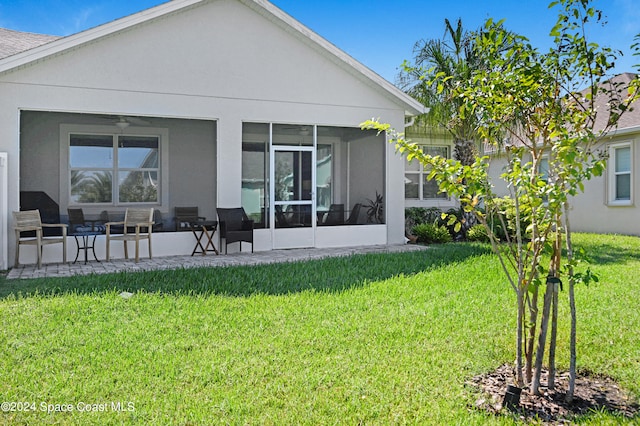 back of house with a yard and a sunroom