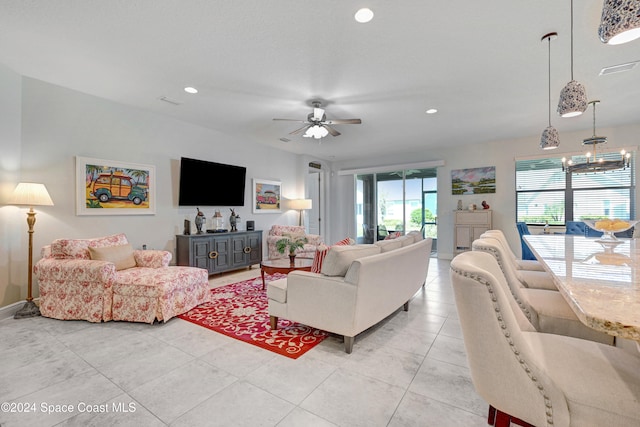 living area with ceiling fan with notable chandelier, light tile patterned flooring, visible vents, and recessed lighting