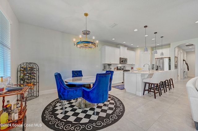 tiled dining area featuring an inviting chandelier and sink