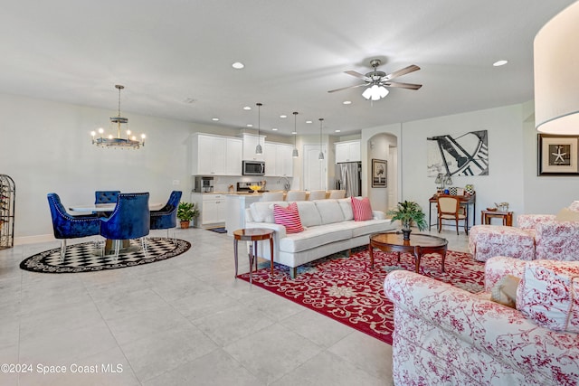 tiled living room featuring ceiling fan with notable chandelier