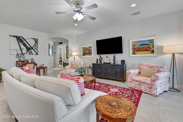 living room featuring arched walkways, light tile patterned floors, recessed lighting, visible vents, and a ceiling fan