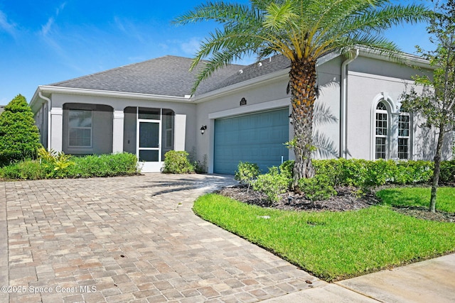 single story home with a garage, decorative driveway, and stucco siding