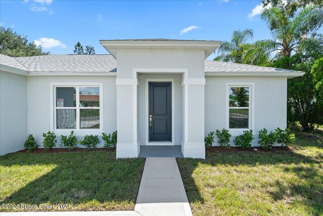 view of exterior entry featuring a yard