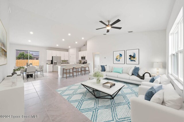 living room featuring light tile patterned floors, high vaulted ceiling, and ceiling fan