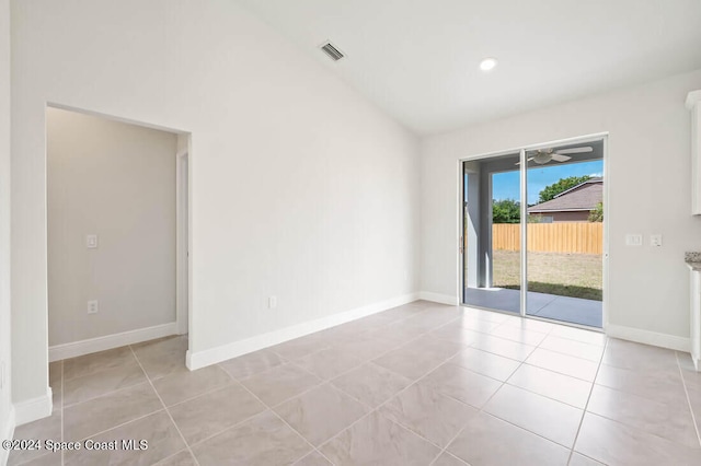 spare room featuring ceiling fan, light tile patterned flooring, and vaulted ceiling