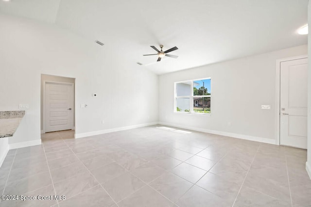 tiled spare room featuring ceiling fan and vaulted ceiling