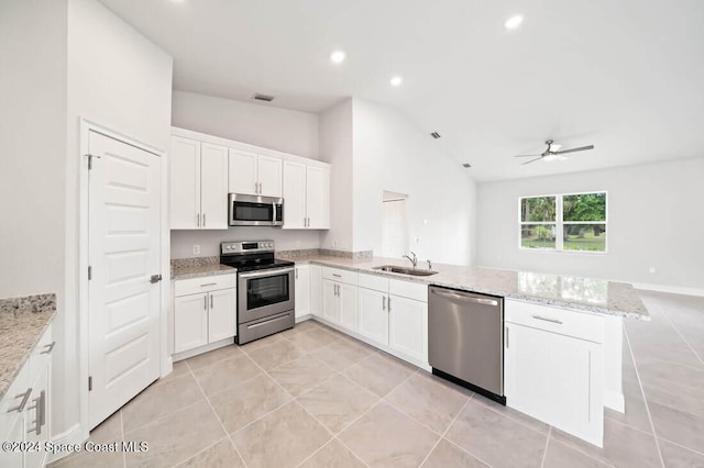 kitchen featuring sink, stainless steel appliances, kitchen peninsula, vaulted ceiling, and white cabinets