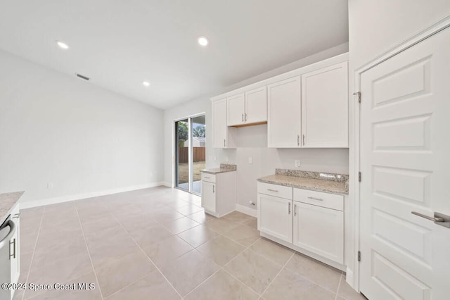 kitchen featuring dishwasher, light tile patterned floors, white cabinetry, and light stone counters