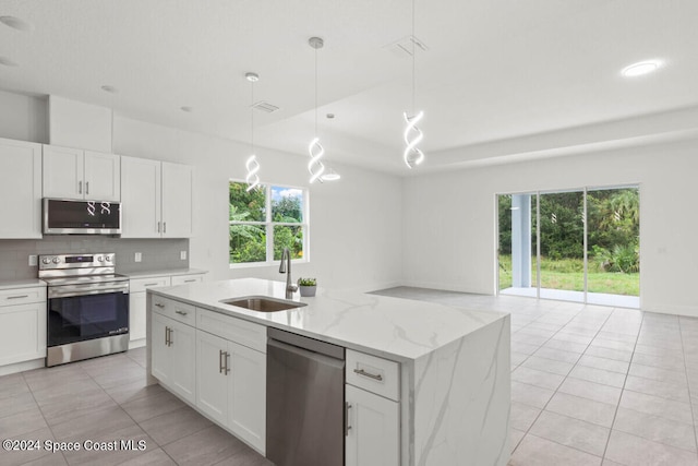 kitchen with white cabinets, appliances with stainless steel finishes, hanging light fixtures, and sink