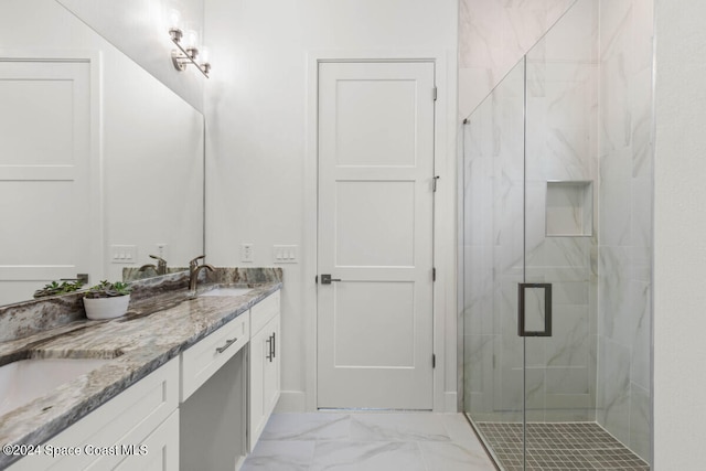 bathroom with a shower with shower door and vanity