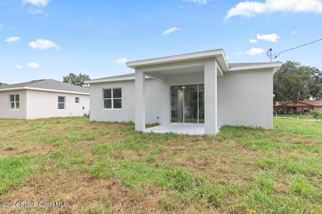 rear view of house featuring a yard and a patio area