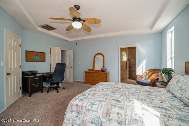 carpeted bedroom featuring a raised ceiling and ceiling fan