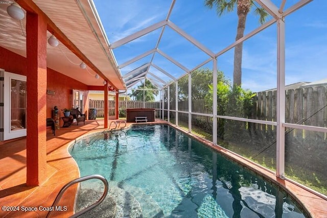 view of swimming pool with a hot tub, a lanai, and a patio area