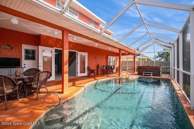 view of swimming pool with a hot tub, a patio area, and a lanai