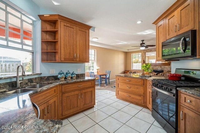 kitchen featuring light tile patterned floors, ceiling fan, dark stone counters, black appliances, and sink