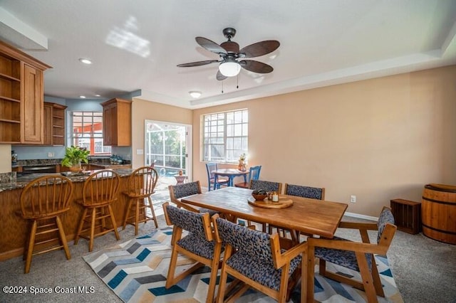 dining space with light carpet and ceiling fan