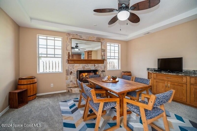 dining area with a wealth of natural light, light carpet, and a fireplace